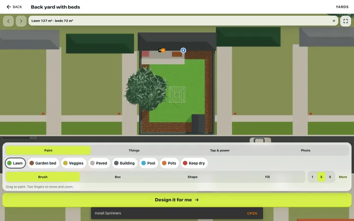 The yard editor on a laptop-sized screen: the back yard from above among the neighbouring houses, with paint, things, tap and photo tools along the bottom.