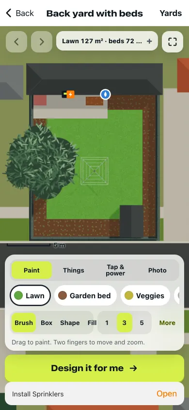 The yard editor on a Coolamon Bay back yard from above: lawn in the middle, garden beds round the fences, a big tree, a shed, and the tap and power point on the house wall. Paint tools for lawn, garden bed and veggies, and a Design it for me button.